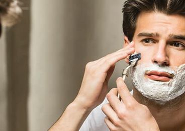 Man shaving in bathroom